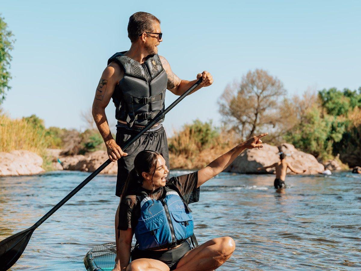 Two people sharing one Redline paddleboard on the river