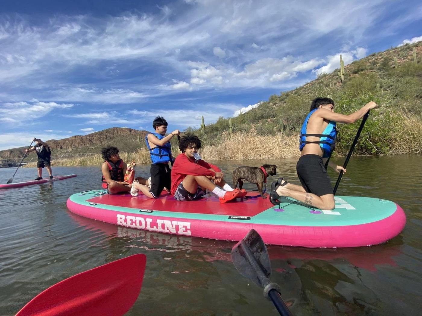 Friends and a dog on the Redline 6-person paddleboard at Canyon Lake