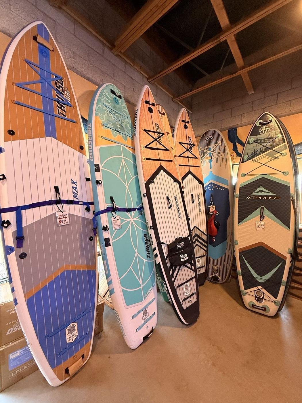 THURSO SURF and ATPROSS paddleboards lined up in the Redline shop