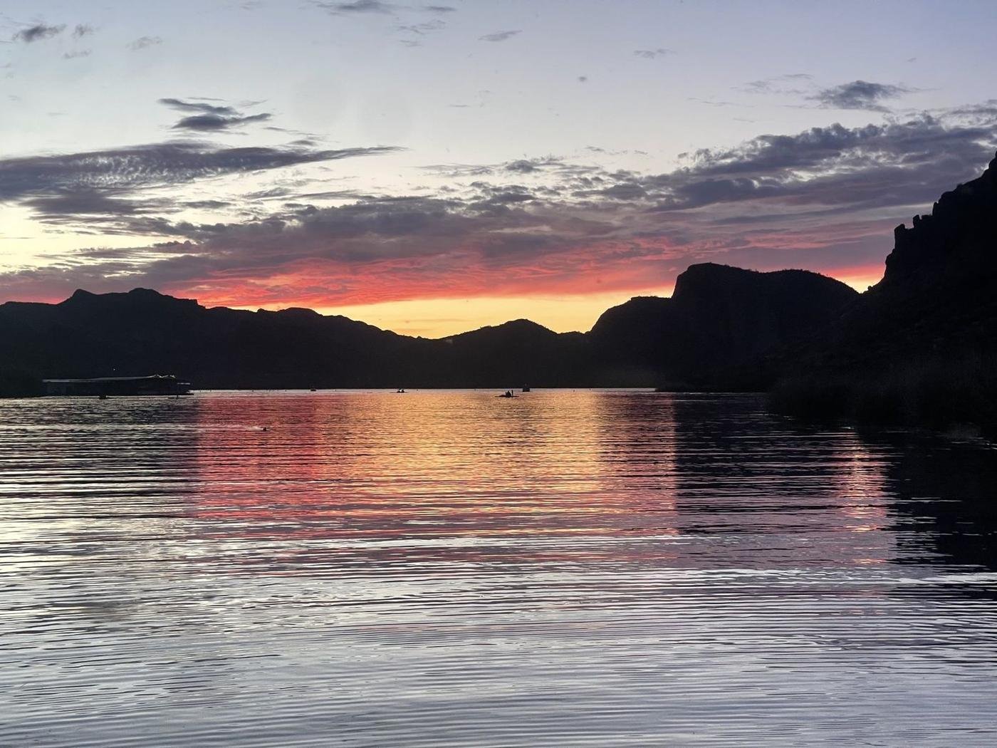 Sunset reflecting on Saguaro Lake with paddlers in the distance